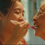 helping senior brush teeth