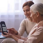 daughter helping elderly mother who resists technology